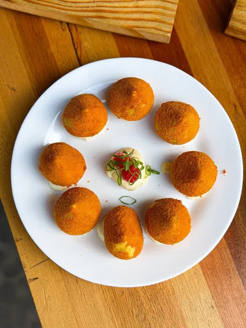 Porção de bolinhos dourados servida em prato branco